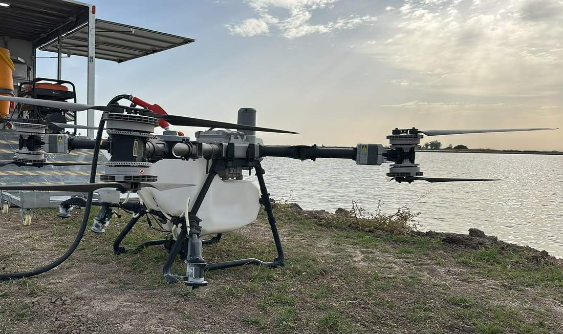 Dron agrícola de DroneSevilla junto a una balsa de agua, durante la carga del depósito