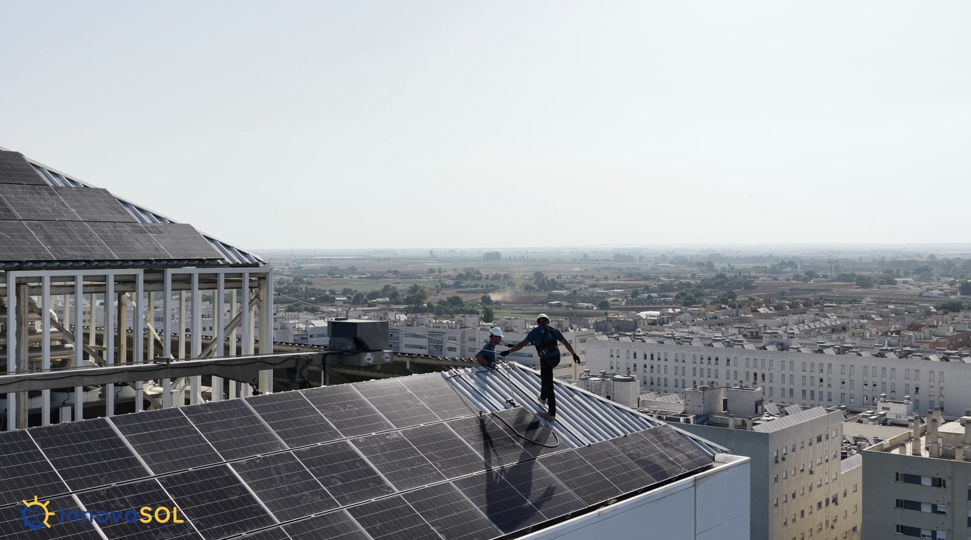 Técnicos de InnovaSol trabajando en el mantenimiento de placas solares en altura, grabado con dron por DroneSevilla